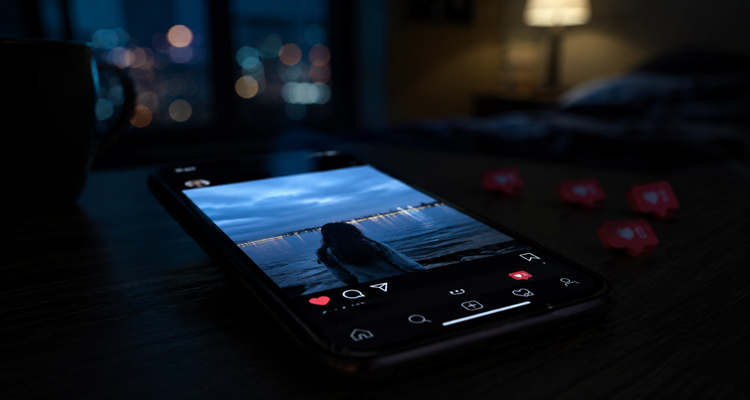 A glowing smartphone displaying a final social media post in a dark room with blurred notifications and an eerie atmosphere.